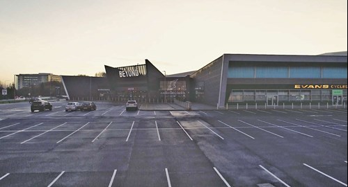 The car park at chill factore with a big BEYOND logo in the background and evans cycles