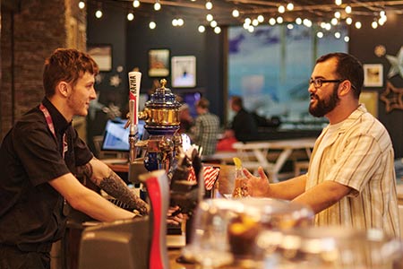 Front of house team member serving a customer at the bar in The Lodge