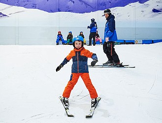 Child skiing down the beginner slope at Chill Factor<sup>e</sup> in a snow plough position