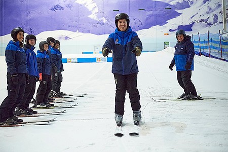 Skier in a beginner ski lesson skiing towards the camera