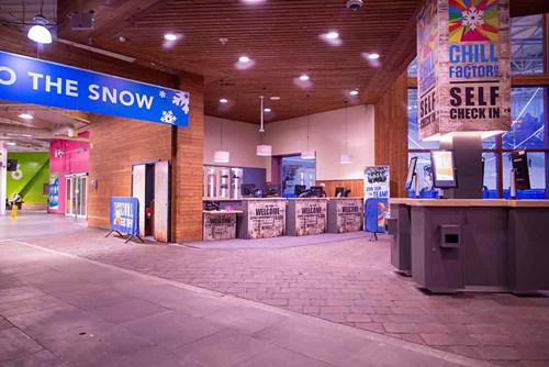 a bunch of check in desks for chill factore with a big check in sign over the reception desk