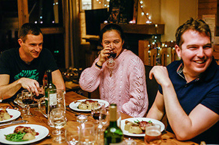 Three people enjoying a meal together facing the camera