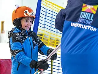 A young boy stood in the snow wearing a blue chill factore jacket